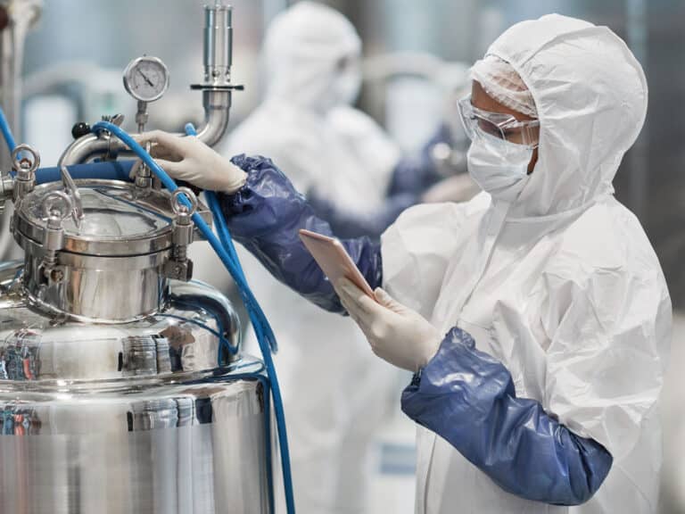 Female worker wearing protective suit while operating equipment
