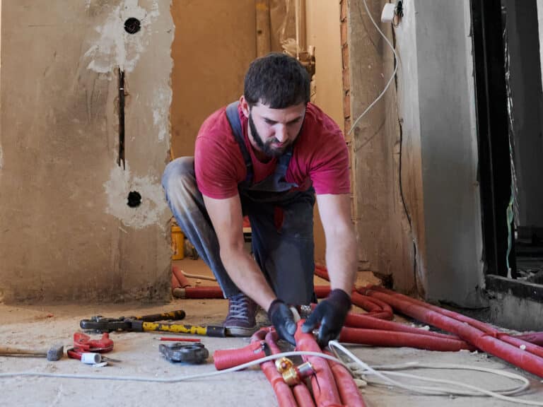 Man in gloves holding water red pipe
